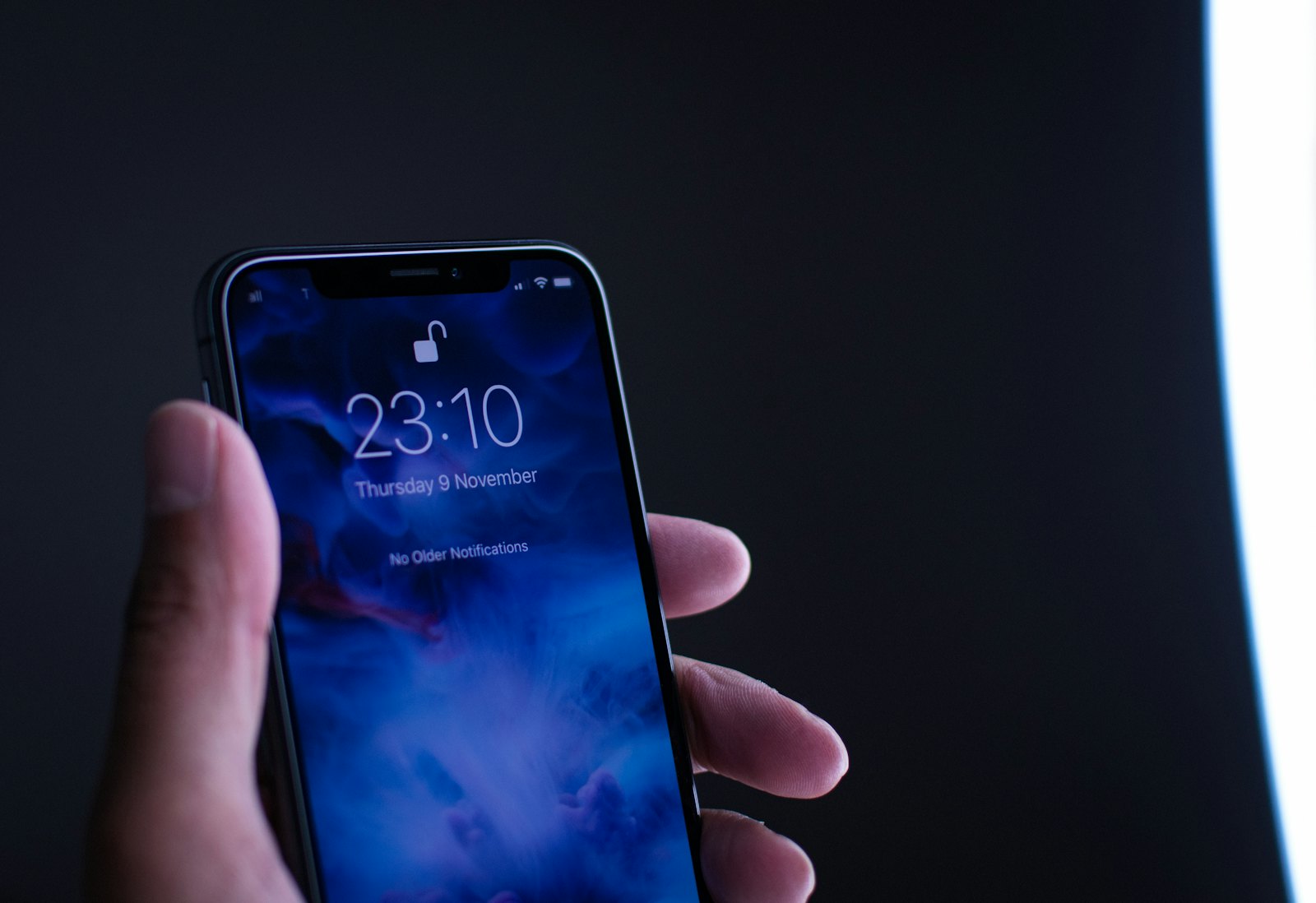 A hand holding a glowing smartphone