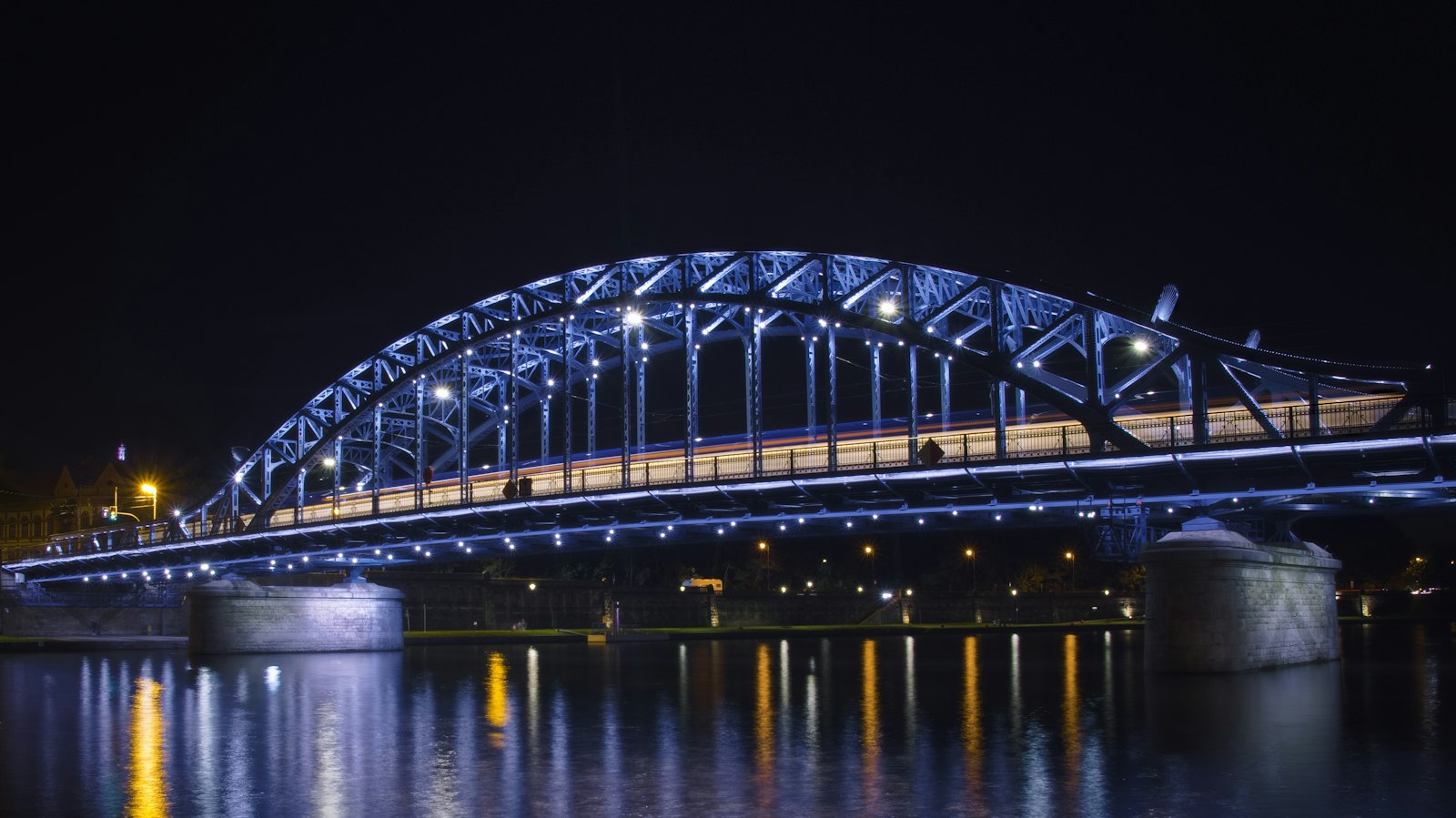 An illuminated arched bridge at night