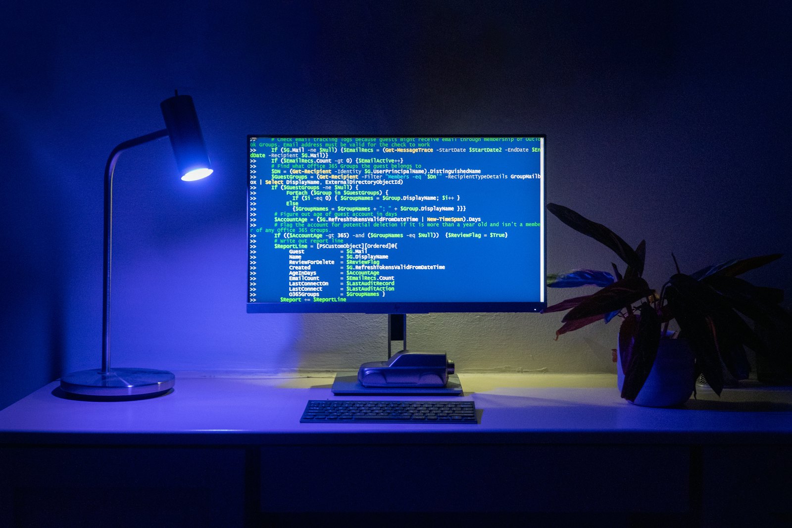 A developer workstation glowing blue in a dark room