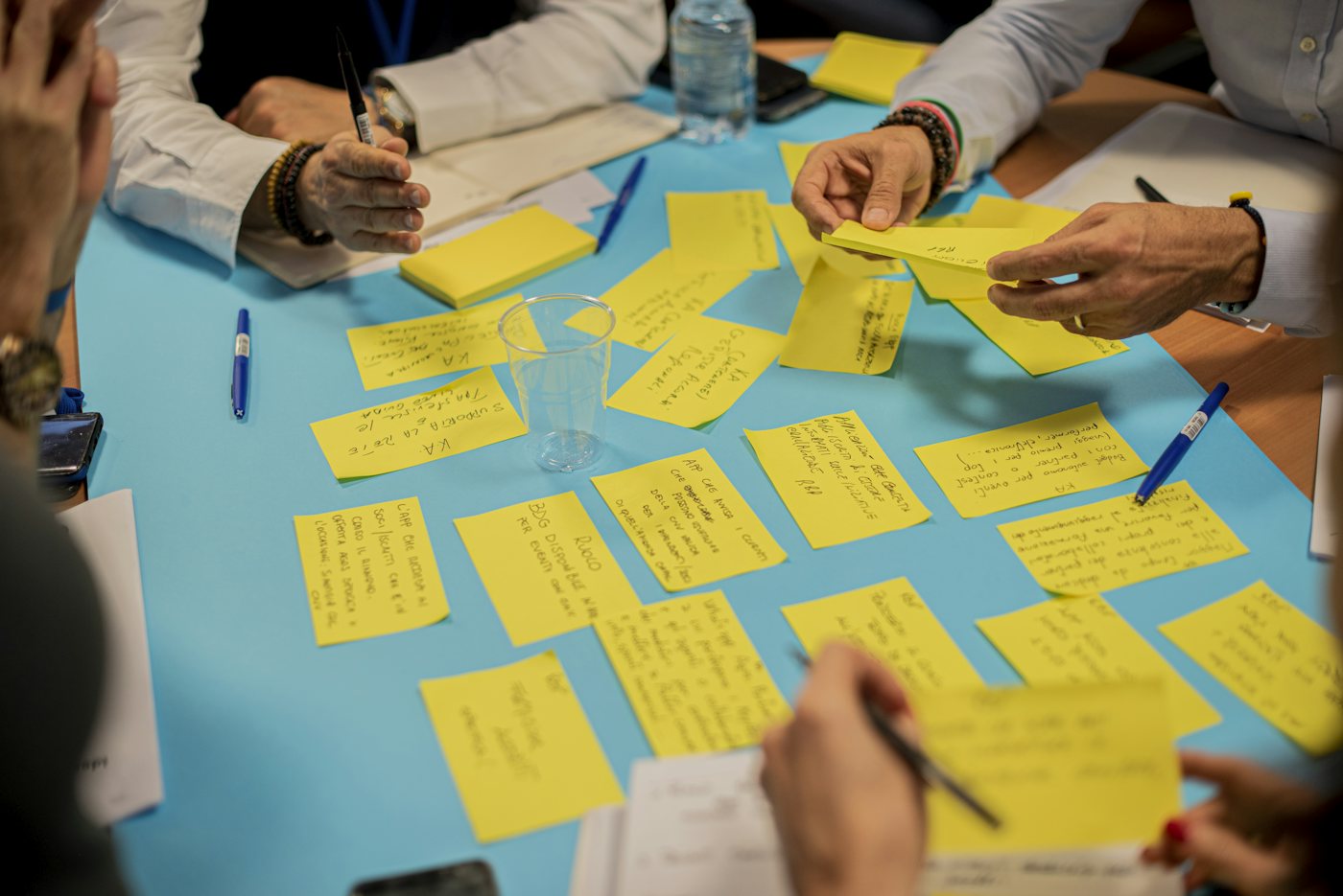 Hands arranging yellow sticky notes on a planning table
